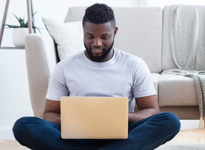 Homem sentado usando um notebook.